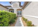Front entry with walkway, shrubs, and neutral-colored siding at 3238 Bailey Ann Dr, Ormond Beach, FL 32174