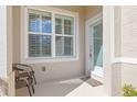 Front entry with two chairs, frosted glass door, and white shutters at 3238 Bailey Ann Dr, Ormond Beach, FL 32174
