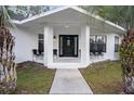 Inviting front porch with seating and a decorative front door, perfect for relaxing at 7024 Sw 93Rd Street Rd, Ocala, FL 34476