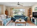 Cozy living room featuring teal and beige sofas, a coffee table, and large windows at 1031 Calle Grande St, Ormond Beach, FL 32174