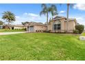 Single-story house with gray garage door and lush green lawn at 4546 Nottoway Dr, Leesburg, FL 34748