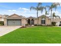 House exterior showcasing a well-maintained lawn and a gray garage door at 4546 Nottoway Dr, Leesburg, FL 34748