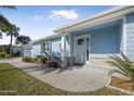 Front view of a charming light blue house with a walkway and landscaping at 149 Sunrise Cove Cir, Ormond Beach, FL 32176