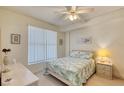 Bedroom with a bed, nightstand, ceiling fan, and window with blinds at 2403 S Atlantic Ave # 309, Daytona Beach, FL 32118