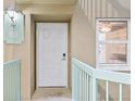 White front door with a keypad lock and a light teal railing at 4 Oceans West Blvd # 206C, Daytona Beach, FL 32118