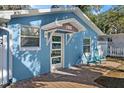 Charming house with a blue facade and a decorative glass front door at 825 Magnolia Ave, Holly Hill, FL 32117