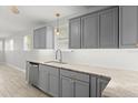 Modern kitchen with gray cabinets, granite countertops, and stainless steel appliances at 825 Magnolia Ave, Holly Hill, FL 32117