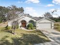 Single-story house with arched entryway, two-car garage, and neat landscaping at 92 Spinnaker Cir, South Daytona, FL 32119