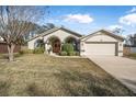 Single story house with arched entryway and attached two-car garage at 92 Spinnaker Cir, South Daytona, FL 32119