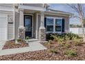 Front door entrance with stone pillars and landscaping at 2212 Oconnel Dr, Ormond Beach, FL 32174