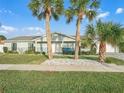Single-story house with a light green exterior and palm trees at 21 Tipperary Ln, Ormond Beach, FL 32176