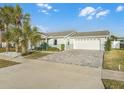 Home with gray paver driveway and palm trees at 21 Tipperary Ln, Ormond Beach, FL 32176