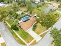 Aerial view of home with screened in pool, landscaped yard, and a concrete driveway at 812 Whiporwill Dr, Port Orange, FL 32127