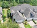 Aerial view of the property highlighting the well-manicured lawn, mature trees, and the roof at 820 Aldenham Ln, Ormond Beach, FL 32174