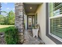Inviting front porch with stone column, bench, and spacious entryway at 830 Aldenham Ln, Ormond Beach, FL 32174