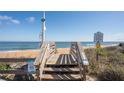 A public beach access point with wooden stairs leading to sandy shores and stunning ocean views at 2100 Ocean Shore Blvd # 1150, Ormond Beach, FL 32176