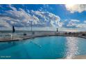 Outdoor pool area with clear blue water, lounge chairs, and an ocean view at 1575 Ocean Shore Blvd # 205, Ormond Beach, FL 32176