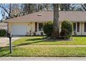 Exterior shot of a cozy home with a lush green lawn, a mailbox, and an attached single-car garage at 1054 W Samms Ave, Port Orange, FL 32129