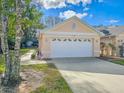 Spacious two-car garage with white door and manicured landscaping at 1187 Athlone Way, Ormond Beach, FL 32174