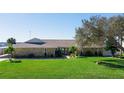 Charming stone home featuring a well-maintained lawn, mature tree, and meticulously landscaped grounds at 2912 River Point Dr, Daytona Beach, FL 32118