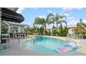 Inviting backyard pool featuring mature landscaping and lounge areas perfect for relaxing and entertaining at 4 Water Oak Cir, Ormond Beach, FL 32176