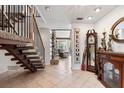 Inviting foyer with a staircase, tile flooring, and a view into the cozy living room at 13 Twin River Dr, Ormond Beach, FL 32174