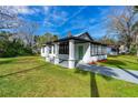 Attractive exterior showcasing covered porch, green lawn, gray walkway, and black trim windows at 134 Knight Pl, Daytona Beach, FL 32114