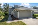 Charming exterior of a townhome featuring a well-maintained lawn, landscaping, and attached two-car garage at 25 Misners Trl, Ormond Beach, FL 32174