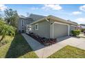 Charming exterior of a townhome featuring a well-maintained lawn, landscaping, and attached two-car garage at 25 Misners Trl, Ormond Beach, FL 32174