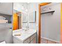 Neutral bathroom with a white vanity, mirror, toilet, and a doorway leading to a closet space for storage at 290 Birch Ave, Orange City, FL 32763