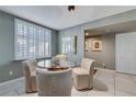 Dining area features a glass-top table with seating for four and window with plantation shutters at 3 Oceans West Blvd # 7C6, Daytona Beach, FL 32118