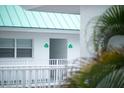 Exterior view showing a balcony with palm tree and a green roof at 3641 S Atlantic Ave # 212, Daytona Beach Shores, FL 32118