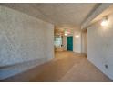 Exterior hallway featuring tile flooring, stucco walls, lighting sconces, and a teal unit door at 4555 S Atlantic Ave # 4708, Port Orange, FL 32127