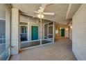 A well-lit corridor with tiled floors, teal doors, and a ceiling fan, creating a welcoming and aesthetically pleasing space at 4555 S Atlantic Ave # 4708, Port Orange, FL 32127