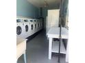 Functional laundry room featuring multiple washing machines, folding table, and sink at 840 Center Ave # 920, Holly Hill, FL 32117