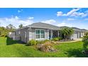 Well-maintained home featuring a lush green lawn and tropical landscaping at 111 Heron Dunes Dr, Ormond Beach, FL 32176