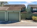 View of the detached single car garage and green wooden fence gate at the front of the townhome at 128 Pine Cone Trl, Ormond Beach, FL 32174