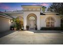 Close-up showcasing the arched entrance, decorative windows, and well-manicured front yard at 1432 Kinnard Cir, Ormond Beach, FL 32174