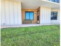 Cozy condo entrance with bench seating and inviting door, with green lawn at 2600 Ocean Shore Blvd # 103, Ormond Beach, FL 32176