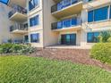 View of the building exterior featuring a patio overlooking a green lawn at 2600 Ocean Shore Blvd # 103, Ormond Beach, FL 32176