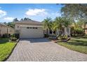 Paver driveway leads to a well-maintained single-story home with stone accents and a two-car garage at 187 Indian Wells Ave, Kissimmee, FL 34759