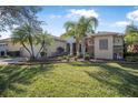 Attractive single-story home featuring a well-maintained lawn, palm trees, and colorful landscaping at 187 Indian Wells Ave, Kissimmee, FL 34759