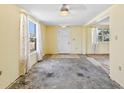 Bright living room featuring neutral walls, large windows, and a white front door at 24 River Dr, Ormond Beach, FL 32176