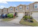 Inviting two-story townhomes featuring neutral paint, attached garages, and beautifully landscaped front yards at 57 Bella Lago Cir, Port Orange, FL 32129