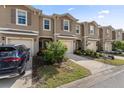 Inviting two-story townhomes featuring neutral paint, attached garages, and beautifully landscaped front yards at 57 Bella Lago Cir, Port Orange, FL 32129