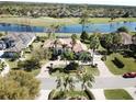 Stunning aerial shot of a single-story home with a terracotta roof, a lake view, and lush landscaping at 1317 Dovercourt Ln, Ormond Beach, FL 32174