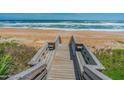 Scenic beach access via wooden walkway to the ocean, ideal for coastal living at 14 Sea Swallow Ter, Ormond Beach, FL 32176