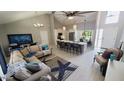 Open-concept living area with vaulted ceilings, adjacent kitchen, and stylish decor at 14 Sea Swallow Ter, Ormond Beach, FL 32176
