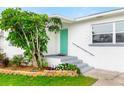 Close-up of the front entrance with turquoise door, small garden, and steps to the house at 168 Boynton Blvd, Daytona Beach, FL 32118