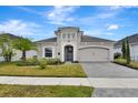 Inviting single-story house showcasing lush landscaping, a brick driveway, and a welcoming front entrance at 604 Mosaic Blvd, Daytona Beach, FL 32124